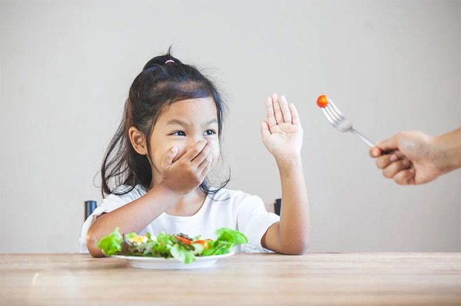 Criança recusando alimentos à mesa